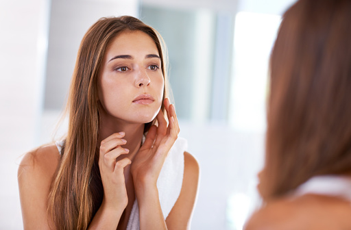 Image of a woman touching her cheek that could have oral cancer.