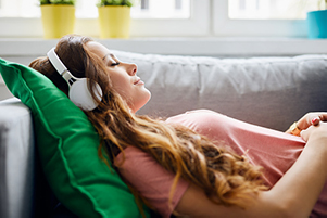 A woman relaxing on the couch after implant placement at Surprise Oral & Implant Surgery in Surprise, AZ