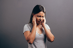 Woman experiencing ear pain.