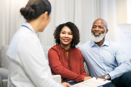 Black patients speaking to dentist about sinus lift at Surprise Oral & Implant Surgery in Surprise, AZ