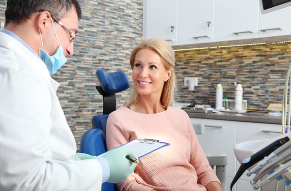 Woman talking to dentist at Surprise Oral & Implant Surgery in Surprise, AZ