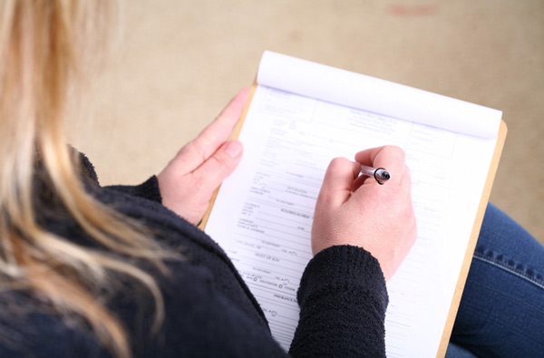 Woman filling out insurance paperwork at Surprise Oral & Implant Surgery in Surprise, AZ