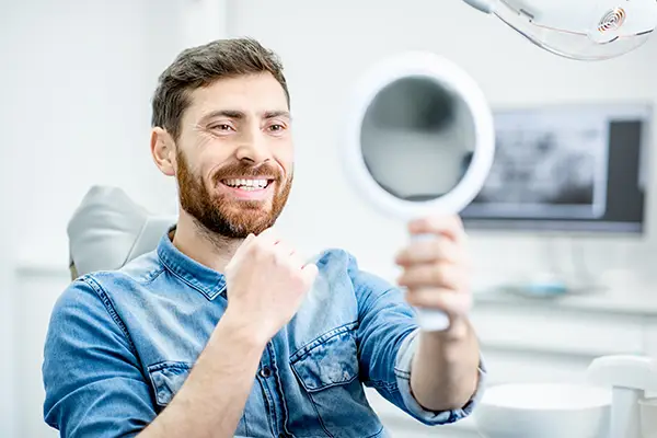 Image of a smiling man looking at his georgeous smile.