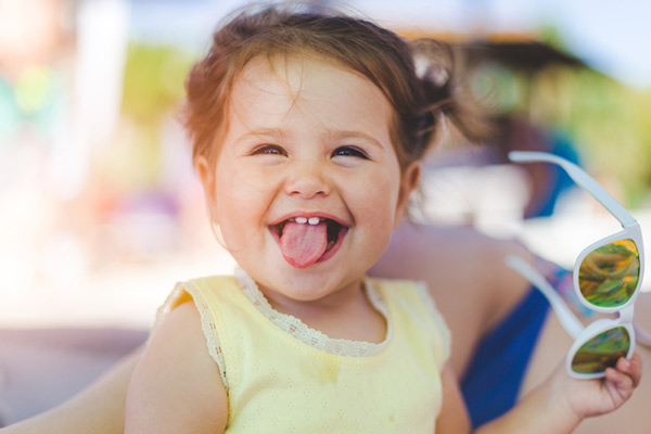 Toddler patient of Surprise Oral & Implant Surgery sticking out her tongue and smiling in Surprise, AZ