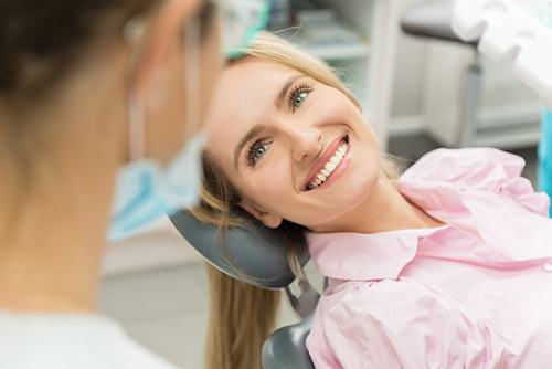 A smiling woman looking at dentist A smiling woman looking at dentist
